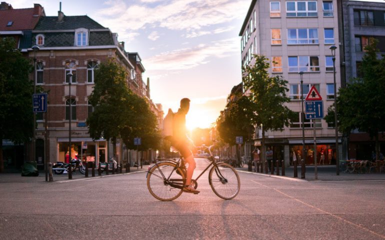 Mann auf Fahrrad vor Sonnenuntergang in der Stadt