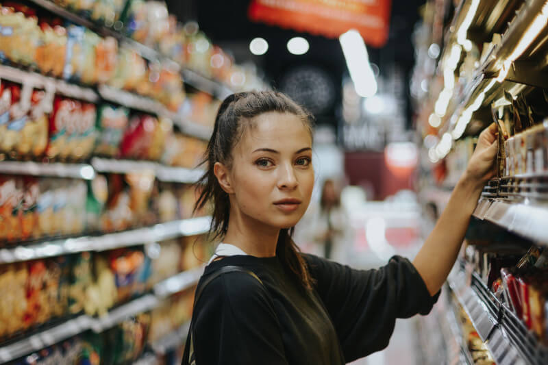 Junge Frau beim Einkaufen im Supermarkt