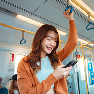 Junge Frau in S-Bahn beim Scrollen durch Online-Stellenanzeigen