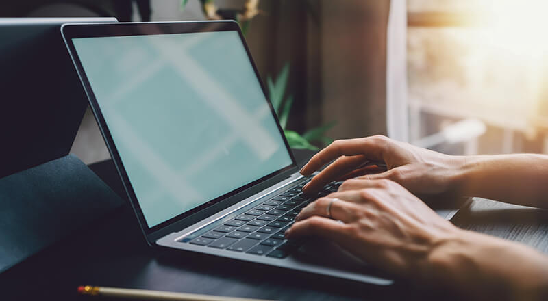 Grauer Laptop auf einem schwarzem Tisch