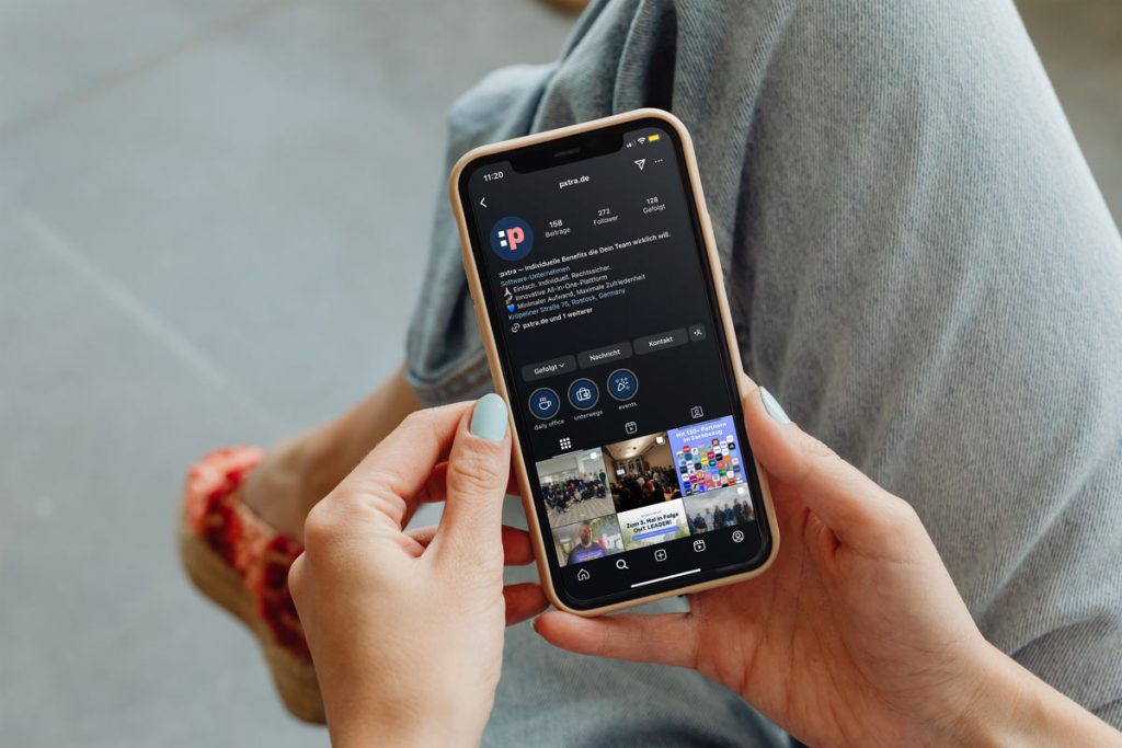Frauenhände halten ein Telefon mit pxtra Instagram-Seite