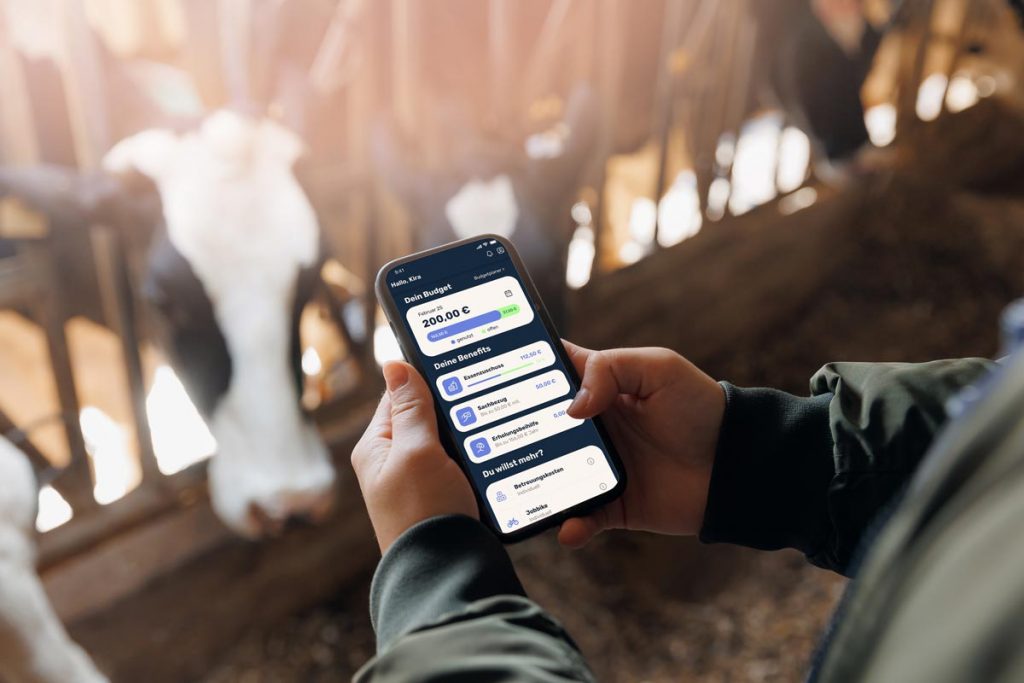 Frau auf dem Bauerhof mit der :pxtra Mitarbeiter-App auf dem Smartphone