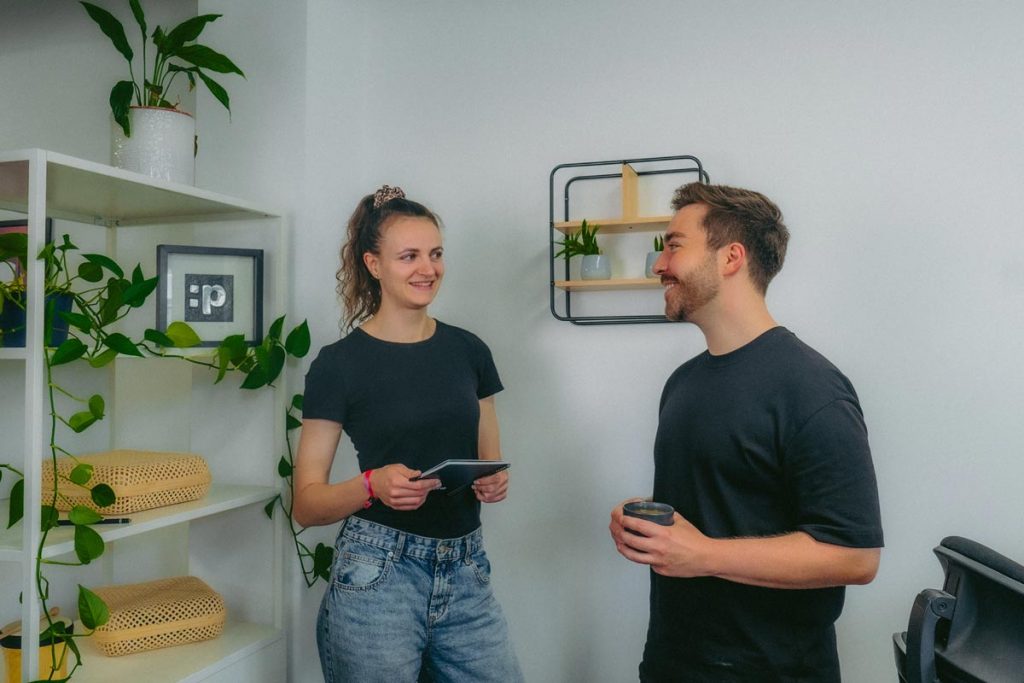 Mitarbeitende Anni und Tom stehen im :pxtra Office und quatschen